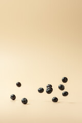 Blueberries falling on a beige background