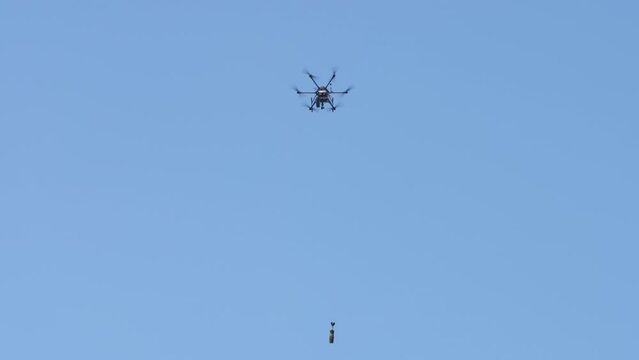 A military remotely controlled drone drops a bomb in the sky. The latest technological guided air weapons.