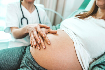 Young pregnant woman with doctor in clinic - Gynecology consultation, medical check-up, maternity and ob-gyn support concept