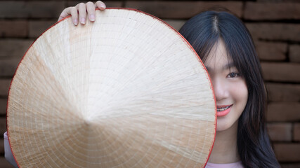 A pretty Vietnamese young Asian girl wearing beautiful Ao Dai a traditional Vietnam dress national...