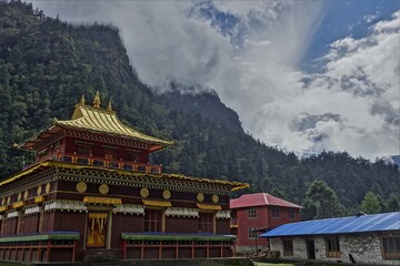 Fototapeta na wymiar Tibetan-style main temple of Hinang Monastery, harmoniously blending with the ethereal presence of the hidden Manaslu Himalayas amidst the cloud cover.
