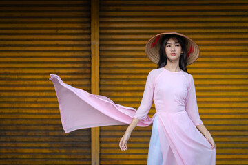A pretty Vietnamese young Asian girl wearing an Ao Dai a traditional Vietnam dress national costume...