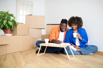 Obraz premium Young Black Family Couple Planning Shopping For New Home, Making Checklist