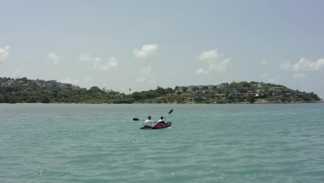 Two person floating in kayak near coral reef . Aerial coastal top view shot. Exotic countries vacations concept.