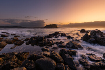 Fototapeta na wymiar Rock formation and Stack Island view with sunrise glow at Minnamurra, NSW, Australia.