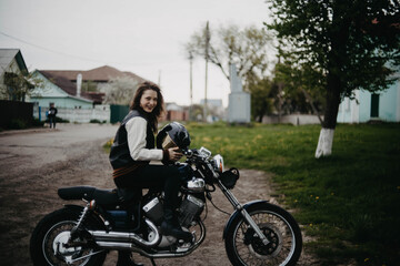 Fototapeta na wymiar beautiful woman motorcyclist on a vintage custom motorcycle. Woman biker