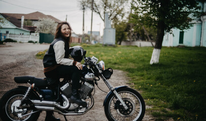 Plakat beautiful woman motorcyclist on a vintage custom motorcycle. Woman biker