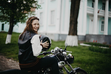 beautiful woman motorcyclist on a vintage custom motorcycle. Woman biker
