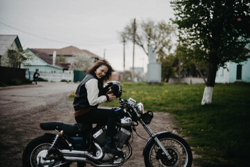 Fototapeta na wymiar beautiful woman motorcyclist on a vintage custom motorcycle. Woman biker
