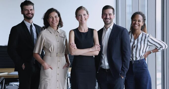 Diverse agency employees smile look at camera. Five multiethnic professionals, office workers, company management gathered together shooting at workplace, feel happy, motivated, enjoy teamwork result