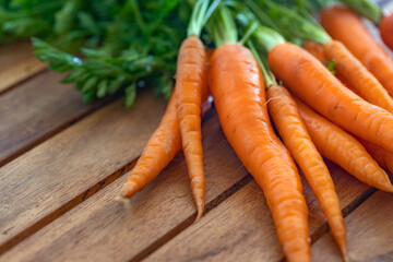 Bunch of fresh carrots on wooden table. Free space for your text