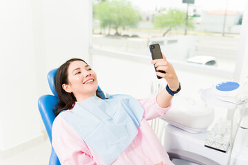 Young woman happy at the dentist taking a selfie