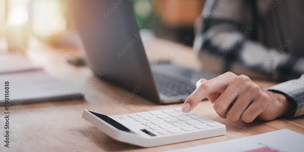 Leinwandbilder accountant using a calculator to calculate numbers ,profit and loss statement review of company performance ,cost analysis ,financial paperwork ,business account checking ,Annual budget planning