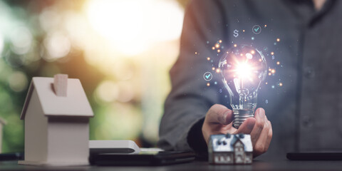 Man holding light bulb showing investment loan approval concept to build a residential house ,real estate business , appraisal of property value ,Finding a location to invest in real estate