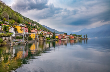 Fototapeta na wymiar Small colorful village with water reflection on Lake Maggiore.