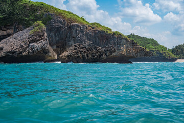 Rock formation on the ocean near the Tanjung Kasap or Cape Kasap, Pacitan, Indonesia. Taken from a moving boat.