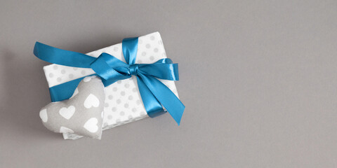 Father's Day celebration concept.Top view flat lay of gift box with satin blue bow balloon and heart isolated on gray background with space for text or promotion and greeting message 