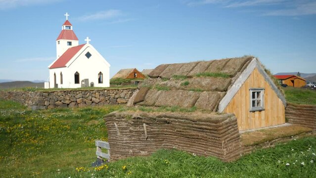 Icelandic church with a typical stone overgrown house covered with grasses in Iceland. Northeast Iceland around Fjallakaffi. High quality 4k footage. 