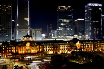 Obraz premium 夜にライトアップされた東京駅の駅舎と丸の内の高層ビルと幻想的な夜景・デートスポット（東京都千代田区）