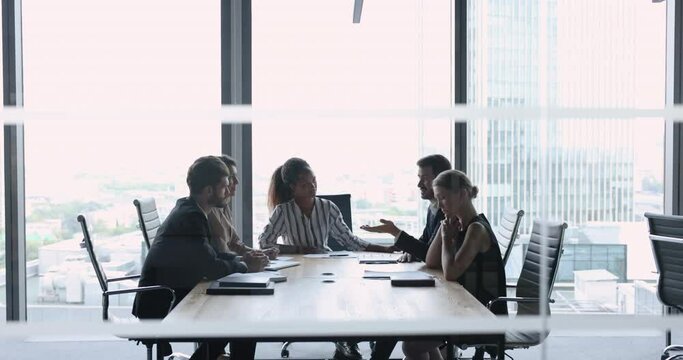 Diverse staff brainstorm in conference room, solve business, search solution, working on collaborative project, sit at desk in modern skyscraper office. Negotiations event of parties, formal meeting