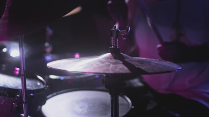 Male Artist hits snare drum, drum kit. Night show in a musical instrument recording studio. The...