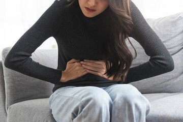 Flatulence asian young woman, girl hand in stomach ache, suffer from food poisoning, abdominal pain...