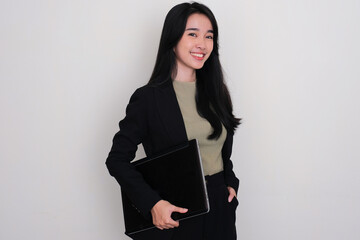 Asian young woman standing and smiling while holding a laptop