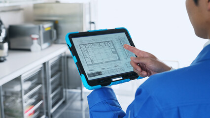 A worker checking the interior design on a tablet.