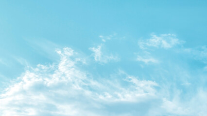 Naklejka na ściany i meble Blue pastel colour sky with white clouds background. Soft blurred cloudscape background. 