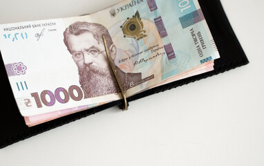 Ukrainian hryvnia money in leather money clip, wallet. Ukraine money on white background with. Currency of Ukraine. Accessories. Money, financess, economy, saving.