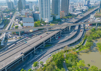 Fototapeta na wymiar Aerial view of cars driving on Ladprao highway junction or moterway. Overpass bridge street roads in connection network of architecture concept. Top view. Urban city, Bangkok, Thailand.