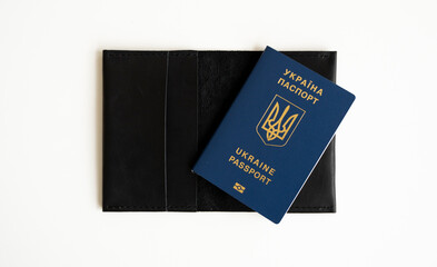 Ukrainian biometric passport id on a leather passport cover to travel the Europe without visas on the table. Inscription in Ukrainian Ukraine Passport.