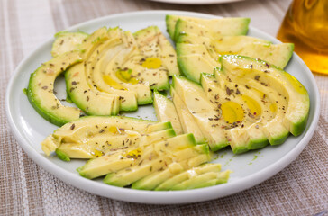 ripe avocado pulp cut into pieces sprinkled with lemon juice on a plate