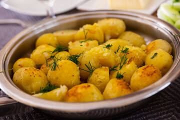 toasted young potatoes with dill in metal skillet