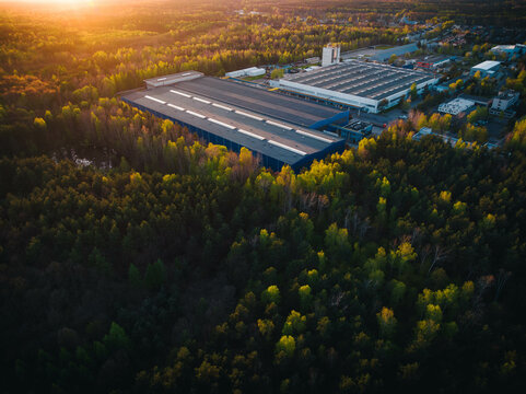 An industrial giant glows in the warmth of the setting sun. The aerial shot captures the magnitude of the building, surrounded by smaller structures.