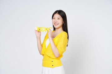 Smiling woman holding yellow glasses isolated over white background.