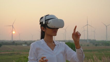 Female engineer wearing vr at wind turbine farm. She using vr to check data or Program at wind...