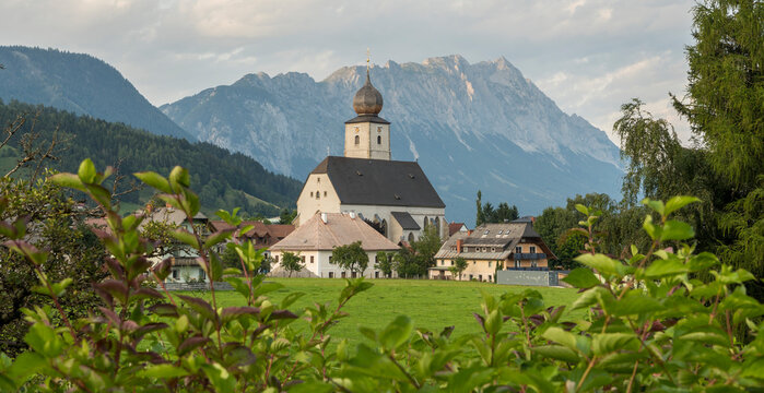 Summer view of Gr&ouml;bming village with the curch surrounded with beautiful Alpine mountains. Alps, summer, Styria, Austria