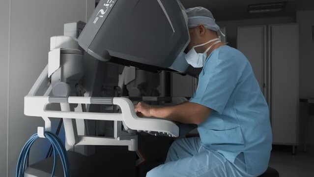 Surgeon performs operation on patient in virtual reality, remotely control robotic arms. Medical robot, modern technology and innovations in medicine. Remote treatment of cancer and infected patients