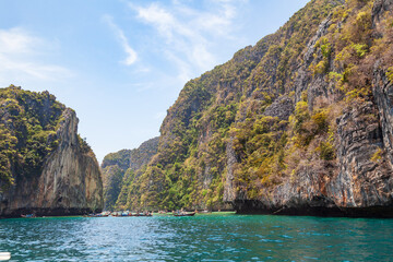 Obraz na płótnie Canvas A picturesque beautiful place on the island of Phi Phi Leh - Pi Leh Lagoon is popular for excursions with tourists on traditional Thai fishing boats. Island travel in Thailand.