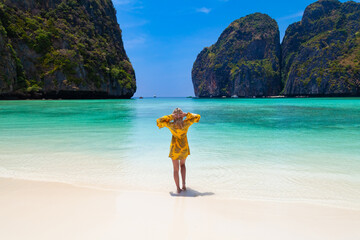 Beautiful young blonde woman in orange dress on a Maya Bay Beach during excursion of phi phi leh...