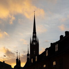 Majestic spires dominate city skyline at sunset, creating captivating silhouettes against the vibrant evening sky.