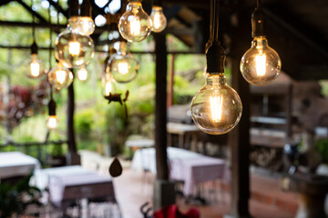 Fototapeta na wymiar lamp with tungsten filament hanging inside an alfresco indoor restaurant