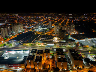 Night aerial photography of the city of Campinas, São Paulo. Dramatic shadows, dark skies and just lights from cars and surrounding buildings. Shopping Unimart and Anhanguera Highway.