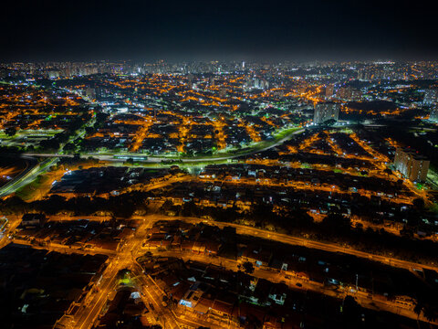 Night aerial photography of the city of Campinas, São Paulo. Dramatic shadows, dark skies and just lights from cars and surrounding buildings. Shopping Unimart and Anhanguera Highway. © Paulo