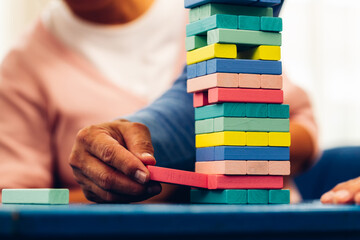 Senior people playing a wooden block tower, risk and strategy of project management. Concept of...