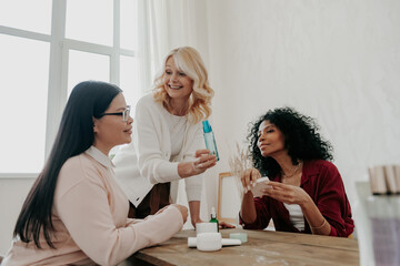 Happy mature woman advising beauty products to her friends while spending time together
