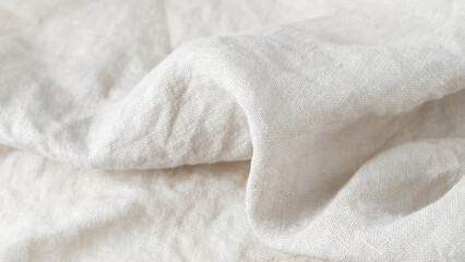 Creased white color natural linen fabric as background with copy space.