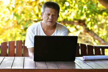 People in white shirt working on laptop computer at home for managing business via home office in holiday. Freelance working using laptop while working at home. Selective focus at computer laptop.