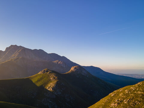 Sun rising over Cradock Peak in the Majestic Outeniqua Mountains, With the City George down towards the sea.  George Western Cape, South Africa, May 2023